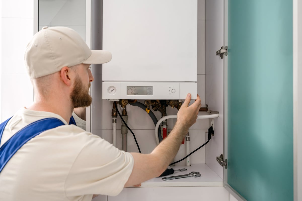 Gas Safe heating engineer inspecting a boiler while replacing an old boiler in a UK home